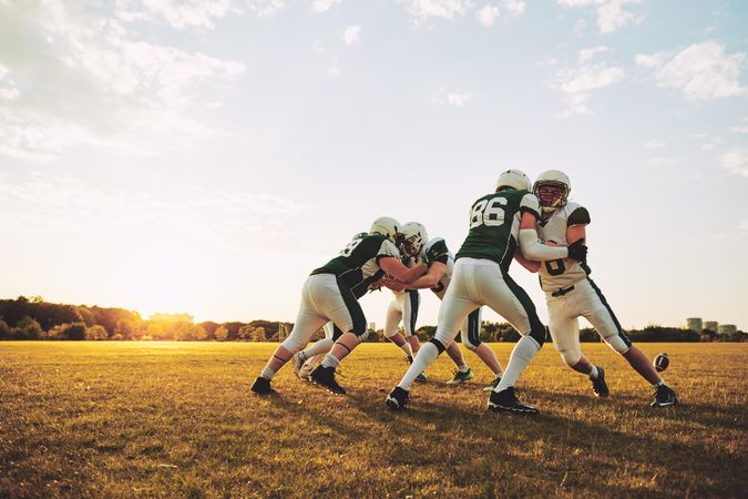 Footballers practicing tackling during practice