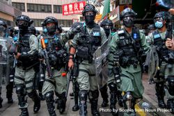 Hong Kong's police officers in full riot gear walking in close-up bxKnj4