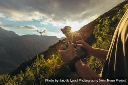 Close up of man hands controlling a drone flying over mountains with remote control 41w7O0