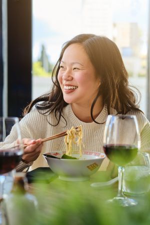 Woman eating ramen in cafe