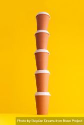 Single stack of disposable coffee cups on yellow background 4MP2E5