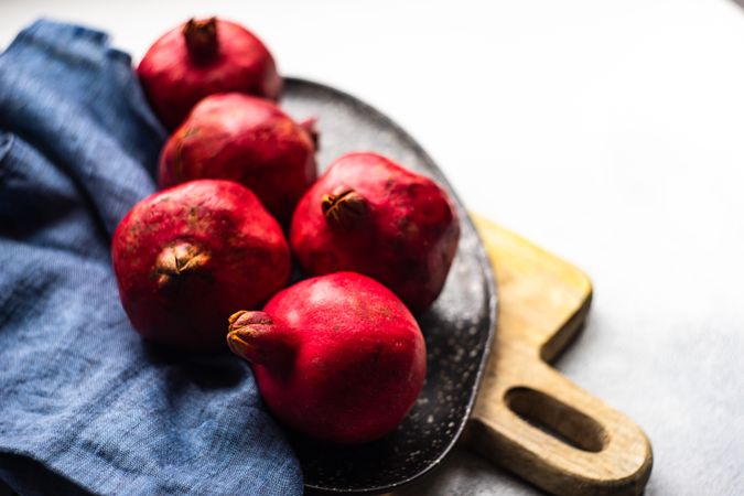 Whole pomegranate on breadboard with napkin