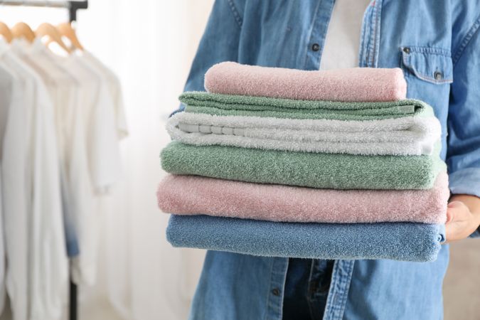Young woman hold clean towels, close up and space for text