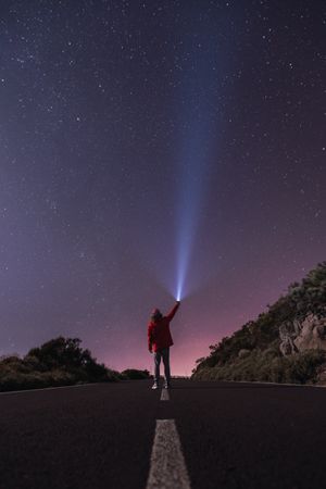 Traveler standing with torch at starry night