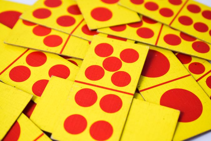 Red & yellow domino cards messily scattered on table