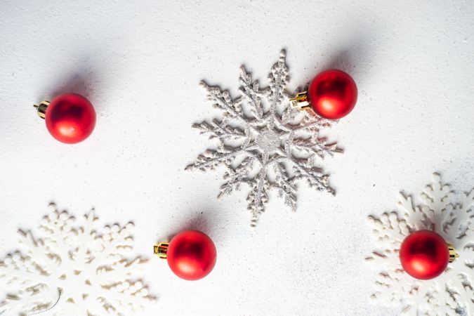 Top view of decorative snow flakes and red baubles