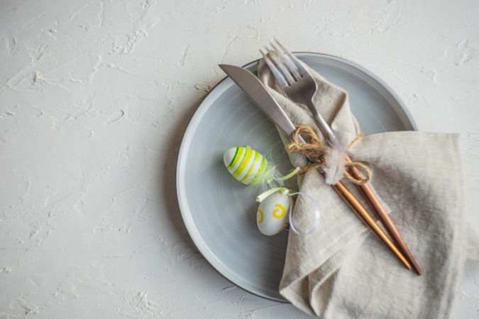 Top view of Easter table setting with green decorative eggs and napkin