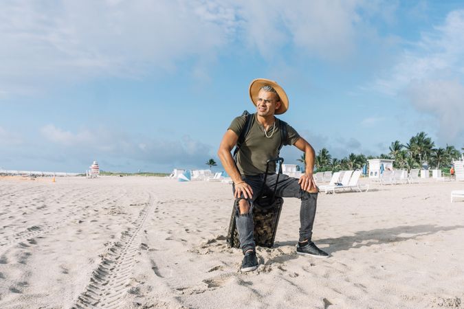 man sitting on the carrying baggage, beautiful beach, enjoying amazing view.