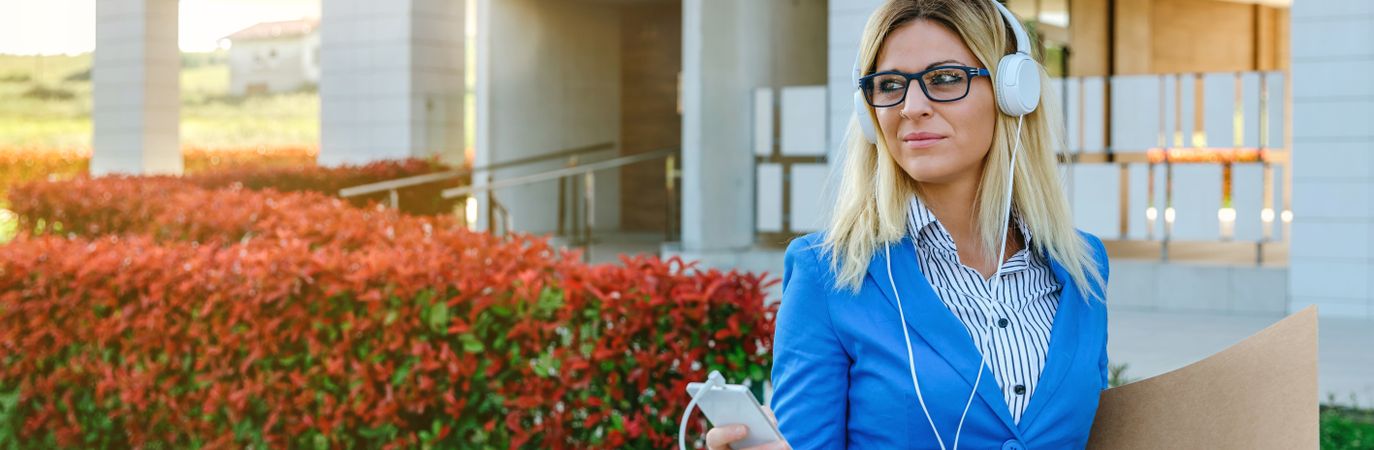 Businesswoman with headphones and mobile