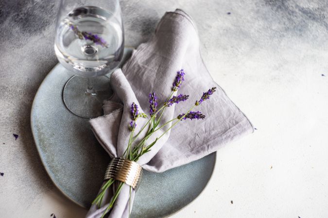Delicate summer table setting with lavender flowers and glass of water