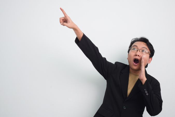 Asian Businessman  shouting loud and  pointing up