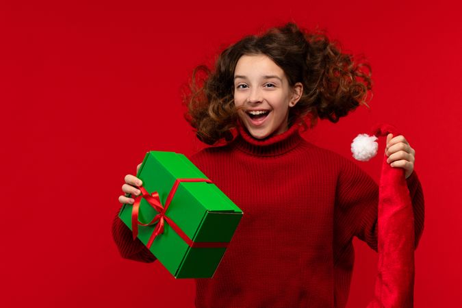 Joyful girl jumps with Christmas gift