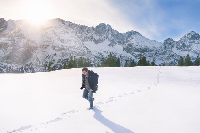 Man walking through snow in mountains