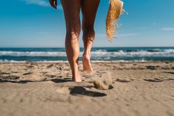 Woman legs on sandy beach