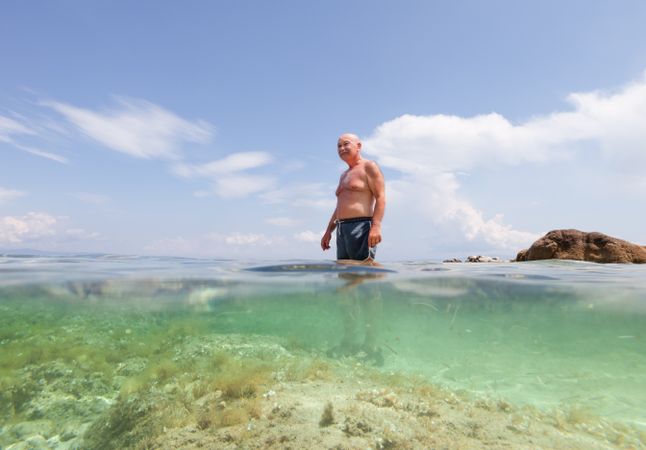 Cheerful man swimming in sea water