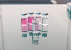 Vials with scientific samples arranged on glass table