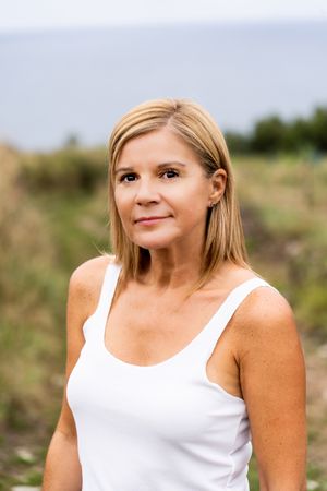 Charming woman looking at camera while walking in countryside