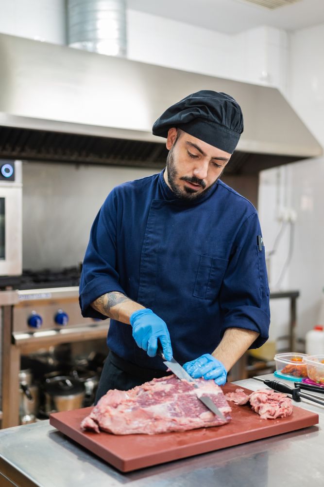 Chef cutting meat in kitchen