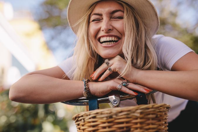 Attractive woman leaning on her bike and laughing