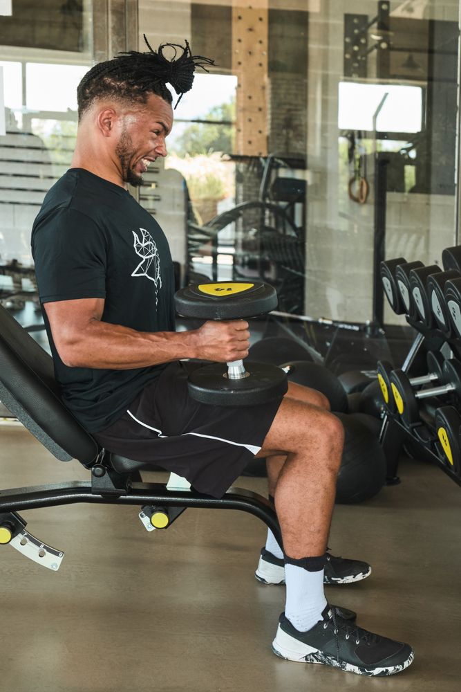 Strong man exercising with dumbbells in gym