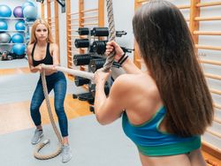 Female athletes training with rope in gym