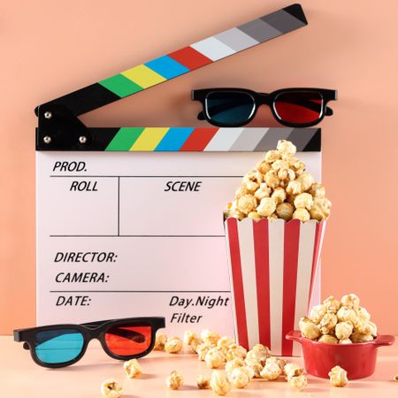 Tasty Popcorn in Buckets, Movie Clapper, and 3D Eyeglasses on a Bright Background.