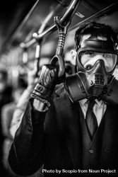 Grayscale photo of person wearing gas mask and suit in train during Hong Kong protests 5qQDY5
