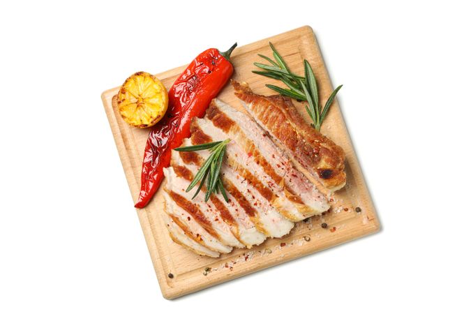 Board with chopped pork steak isolated on blank background