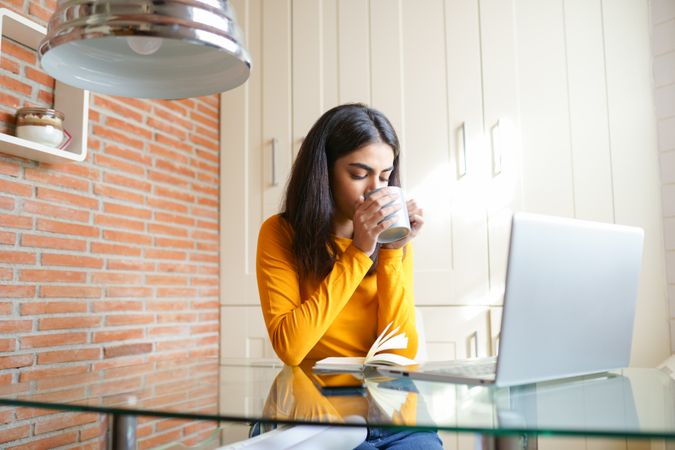Female architect sipping coffee while working from home