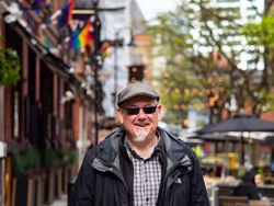 Happy man standing outside in sunglasses and hat