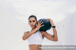 Portrait of woman trainer holding medicine ball on her shoulder 4A3rq0
