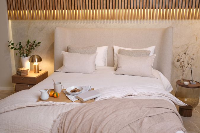 Wooden tray with breakfast on bed