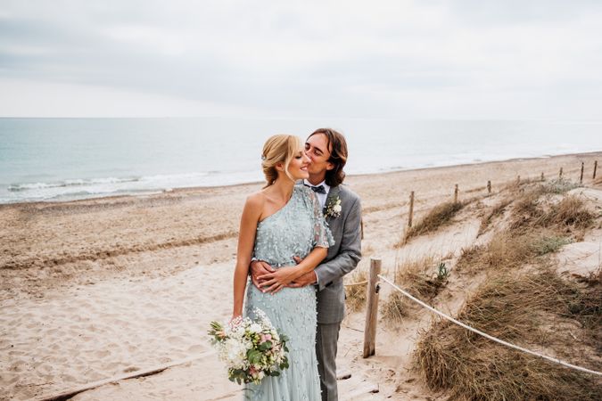 Happy young married couple spending time together at seaside