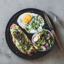 Avocado toast on sourdough bread with herbs and sprouts, square crop
