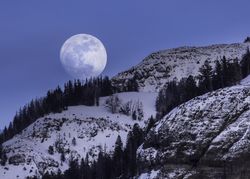 Stunning moonrise over snowing mountains in Yellowstone National Park