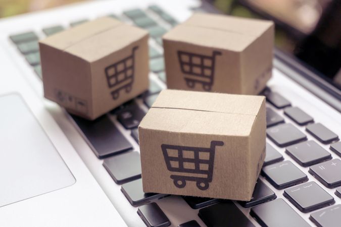 Small Carton Boxes with Shopping Icons on a Laptop Keyboard