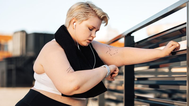 Fit woman leaning on a railing on the roof