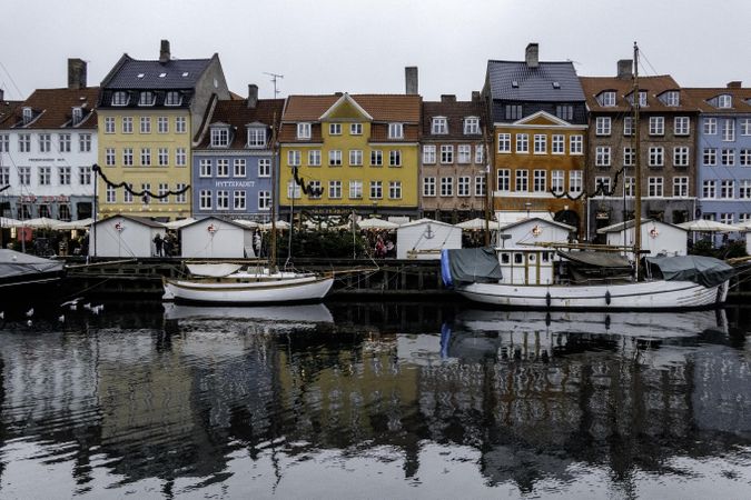 Boats lining river in Denmark with colorful homes