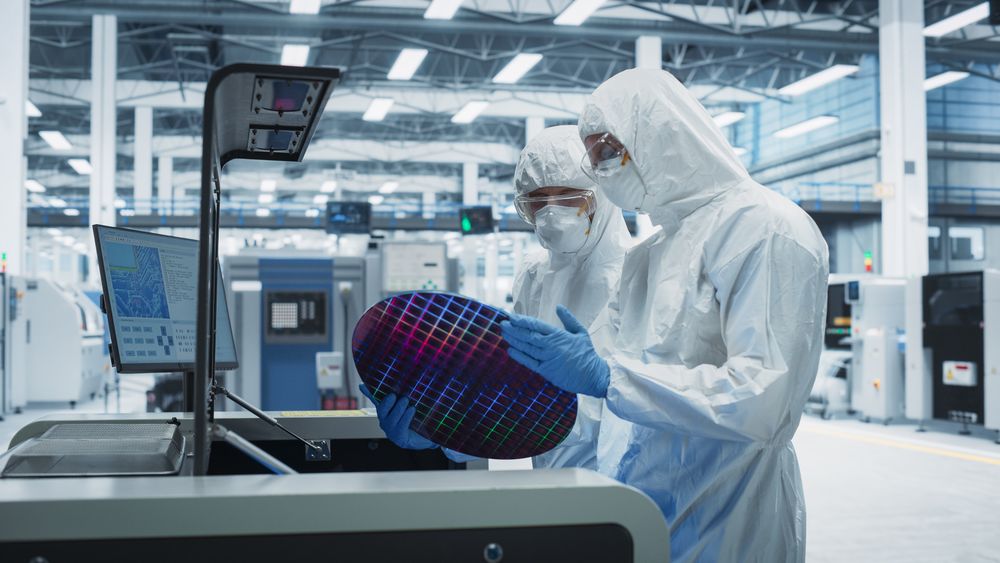Scientists in hazmat protective suit working in lab