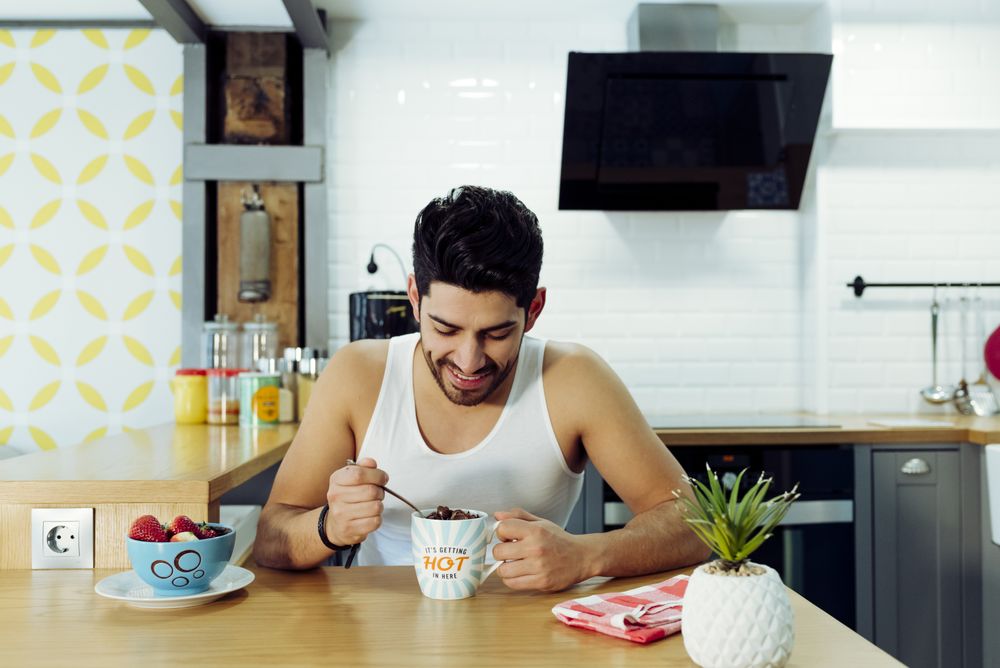 Happy man holding cup of coffee with chocolate