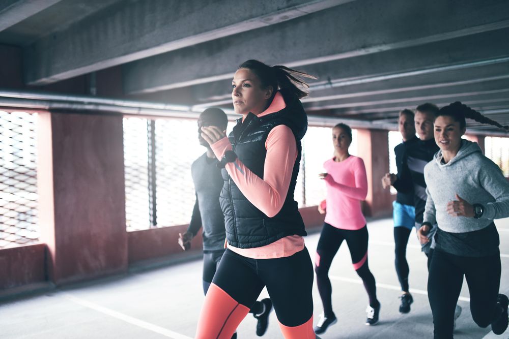Woman in puffer vest running ahead of the group