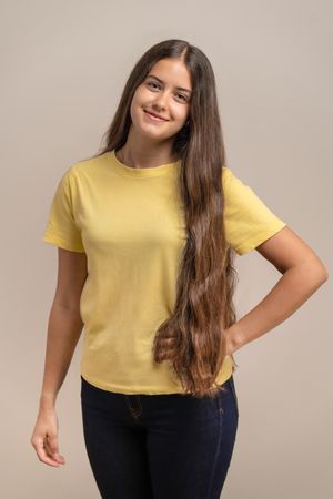 Confident young woman with hand on hip posing for a studio portrait.