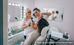 Portrait of make-up artist working with a female client in a beauty center 4OdPjZ