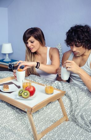 Couple having breakfast and coffee in bed served over tray