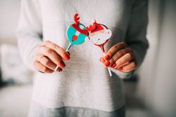 Woman holding festive reindeer and Santa edible ornaments