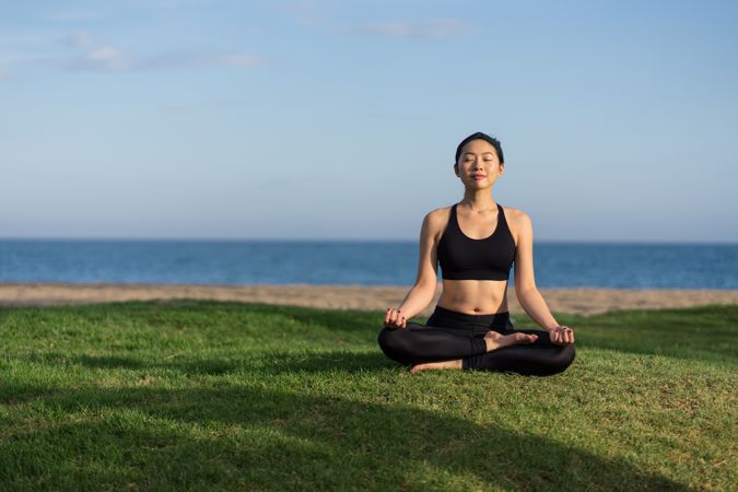 Woman meditating on the beach
