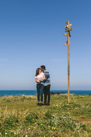 Couple kissing embraced by a direction sign