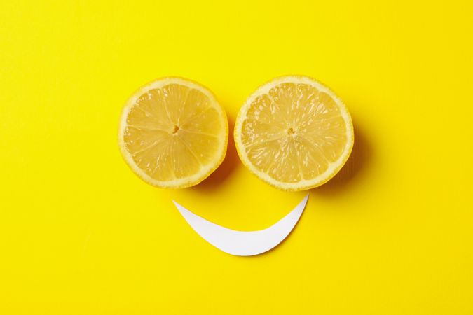 Smiley face made of lemons on yellow background