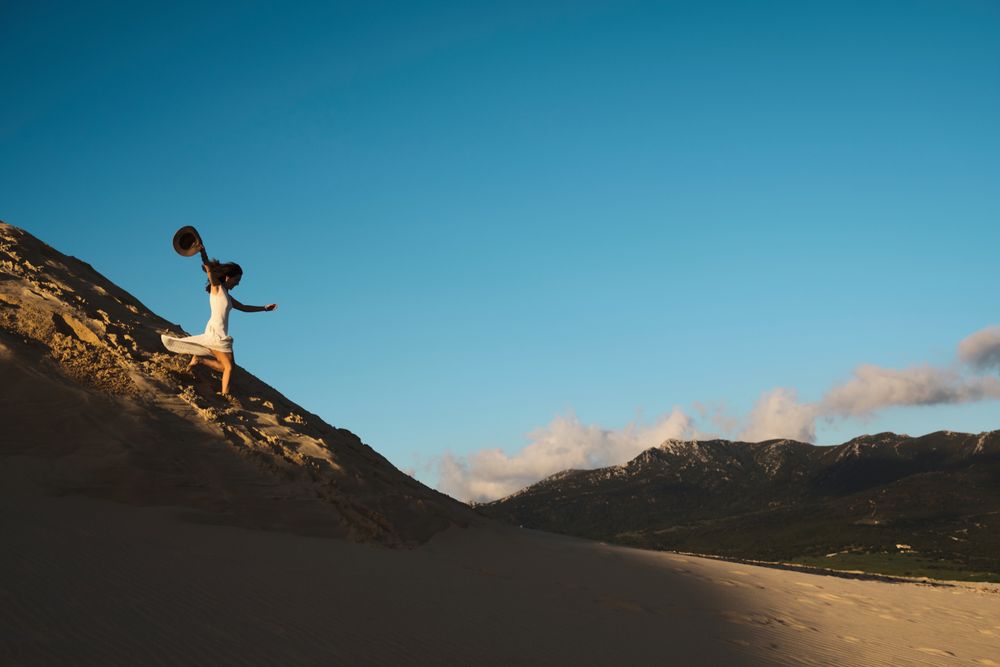 Woman running down sandy hill
