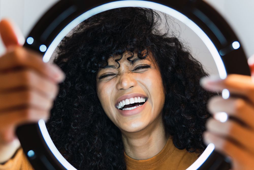 Excited Black woman with ring lamp